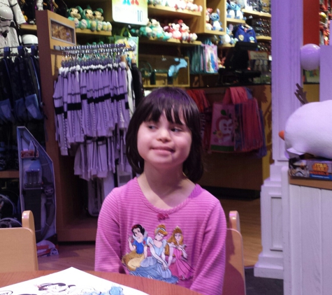 Disney Store - Atlanta, GA. Gracie torn between smiling for camera,  & watching the Disney screen.