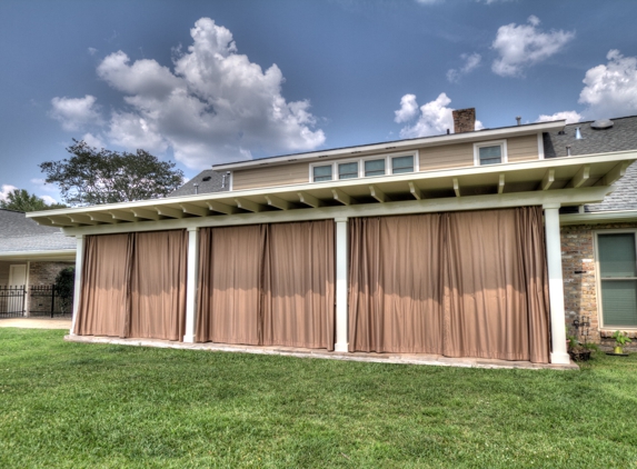 ABC Home Improvements - Baton Rouge, LA. Outside view of a covered patio with closed curtains | Custom Patio Cover Arbor in Baton Rouge - www.lasunrooms.com