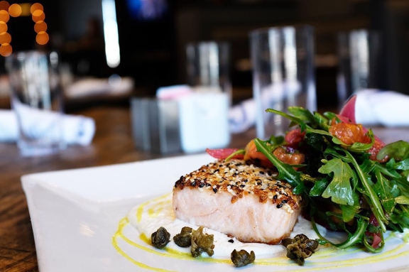 Soulshine Tavern & Kitchen - New Albany, OH. Everything Crusted Salmon, served with a lemon horseradish crème fraîche, petit arugula salad, pickled red onion, tomato, crispy capers, and