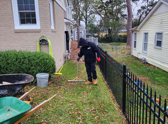 Albright Solutions - Flint, TX. A crew member sweeping the yard with a magnet to catch nails and debris after installation.