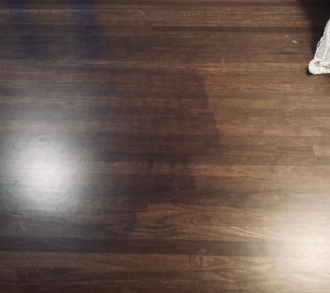 Glenn Mills Floor Sanding & Polishing - Townsville, QLD. Photo of polished floor with dark lines of tint not applied evenly. Glen Mills told us to put a rug on it rather than want to fix his mistake