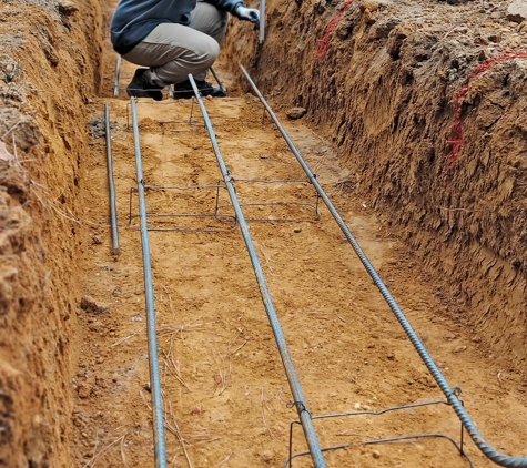 Four Oaks Residential - Four Oaks, NC. Horizontal steel reinforcement installation. Crew is checking depths with our laser level.