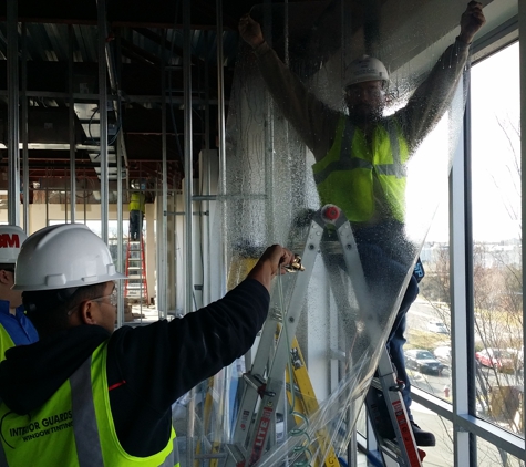 Interior Guards Window Tinting & Graphics - Rockville, MD. Crew installing 3M Security film to a building in Reston Virginia